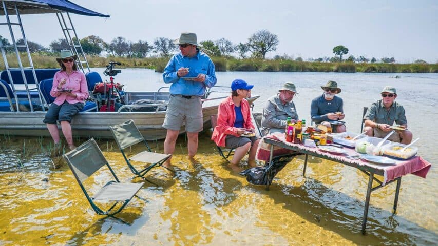 A group of travelers in Botswana having a meal together.