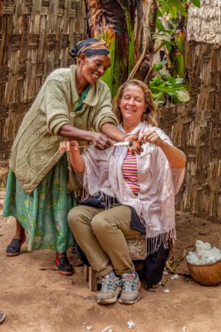 A tourist learning how to spin cotton in Ethiopia.