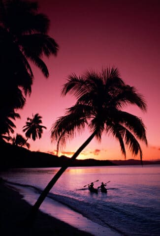 A two sea kayakers at sunset.