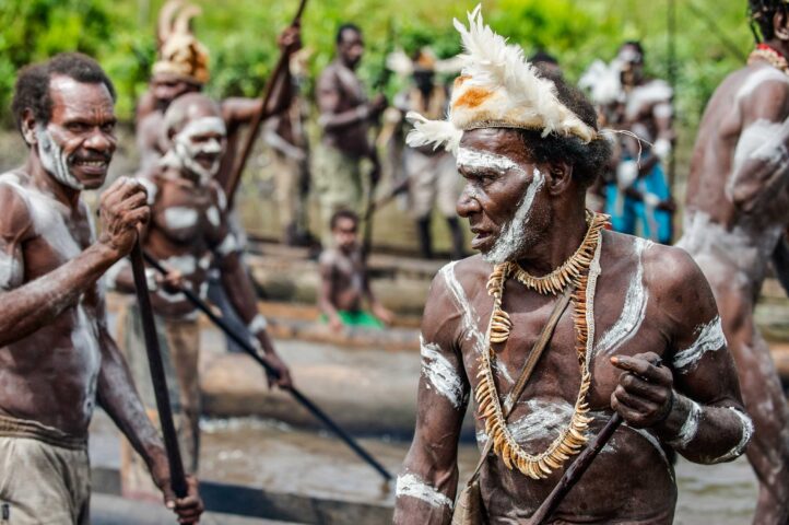 Group of Asmat with a traditional painting on a face.