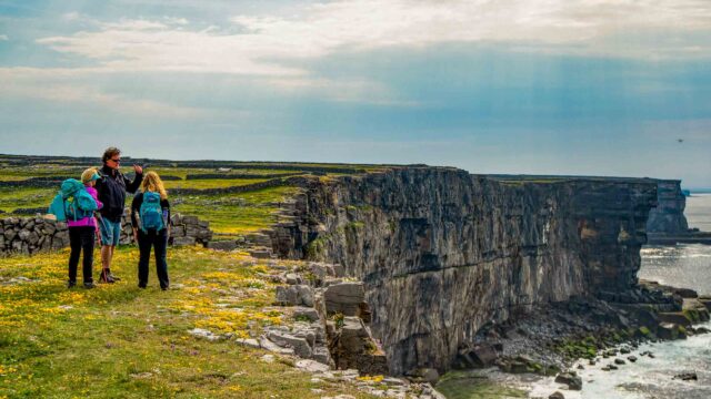 A group of tourists admiring cliffs in Ireland.