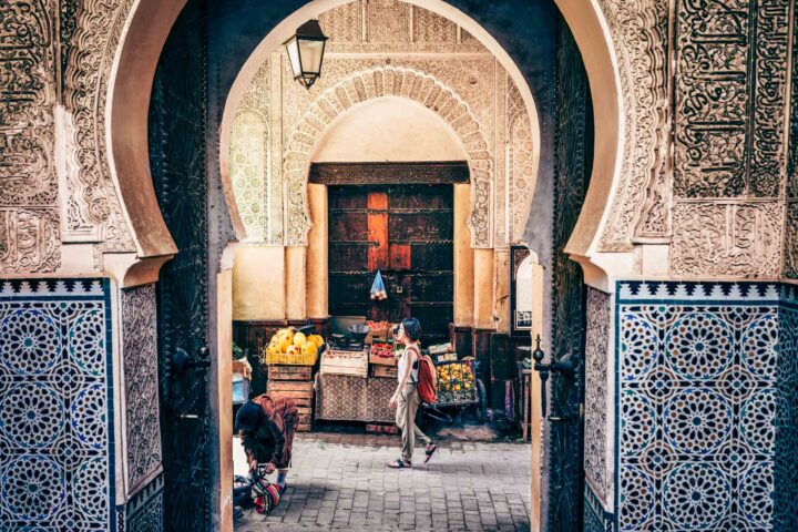 A tourist walking by a market.