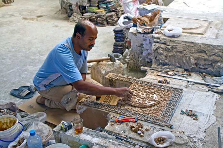 A person working on restoring an ancient relic.