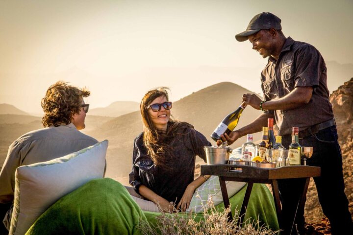 A guide serving drinks to a couple.