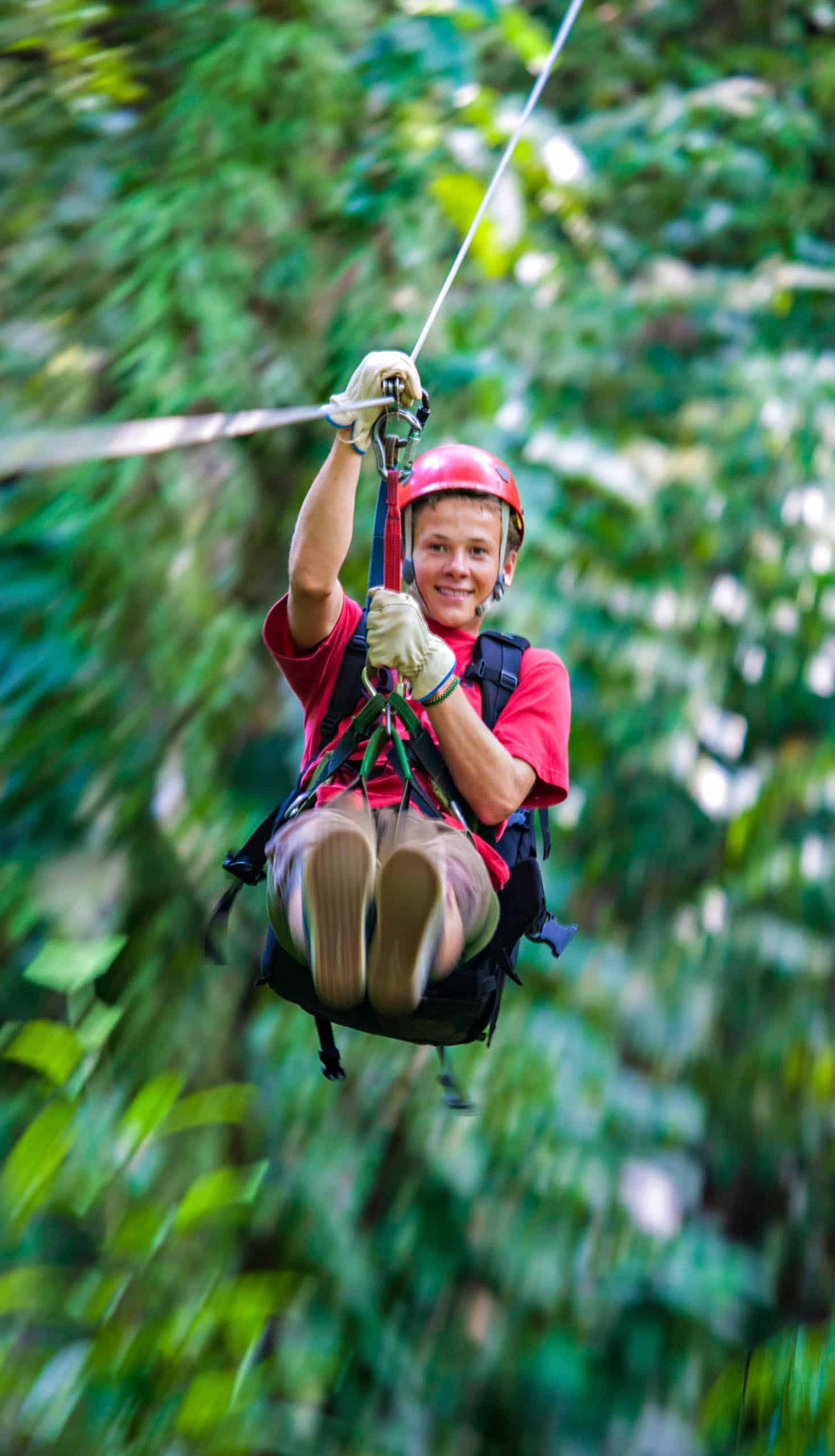 A boy riding a zipline.